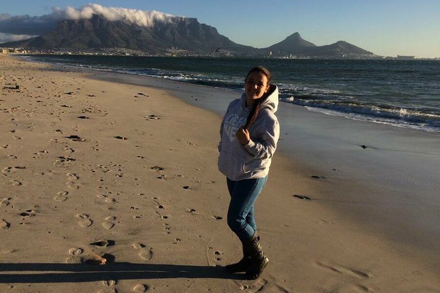 Girl standing on a beach with Table Mountain, Cape Town, in the background